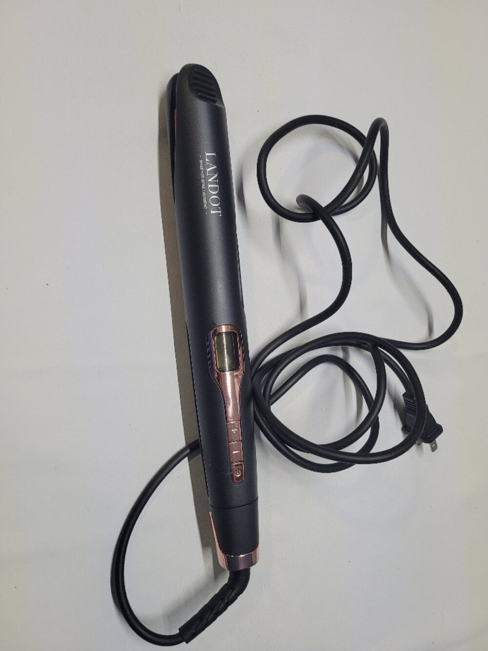 Landot ceramic hair straightener in a sleek black and rose gold design. Features
